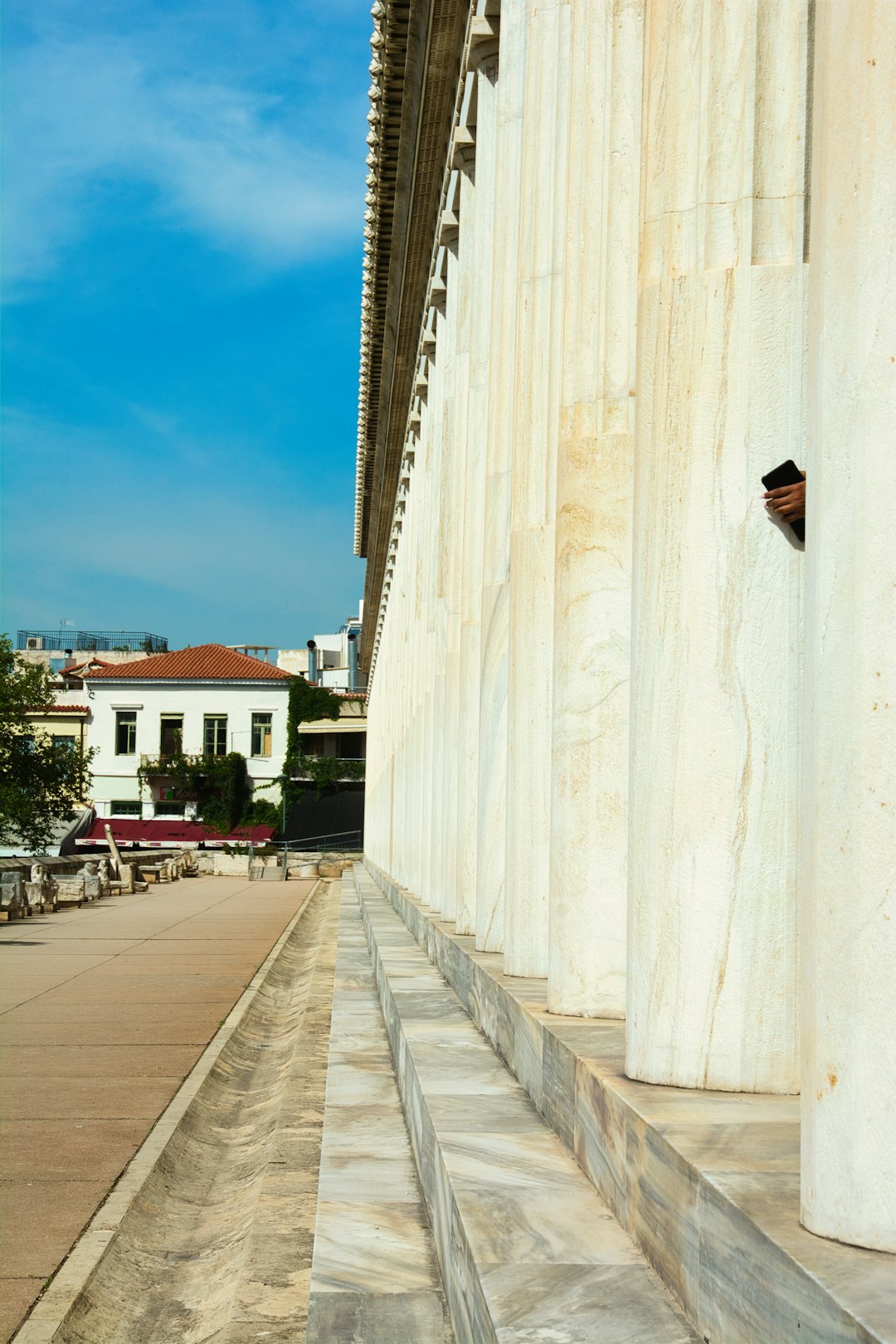 A child holding a mobile phone in an archeological site.