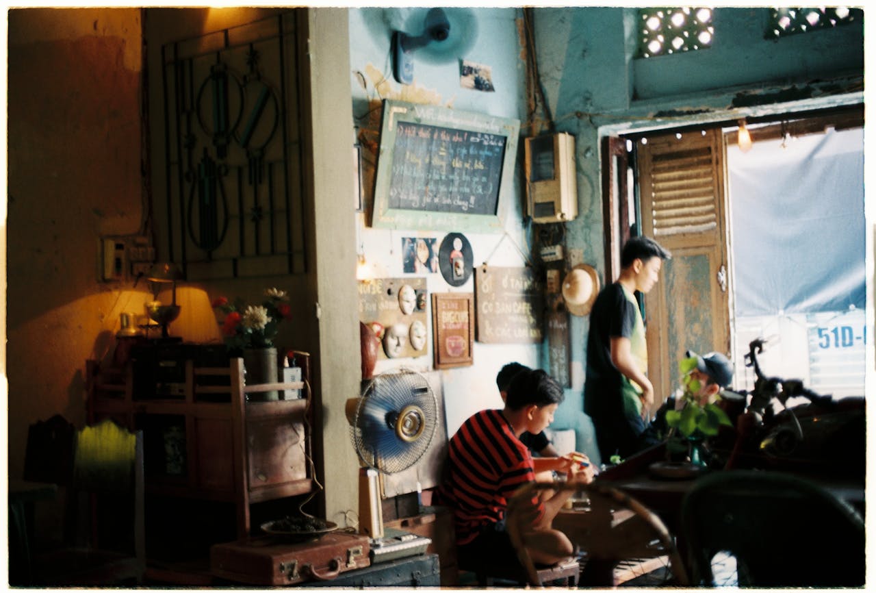 A cozy vintage cafe with two Asian men, retro decor and soft lighting.